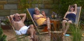 Badegäste sitzend auf Stühlen im Saunagarten